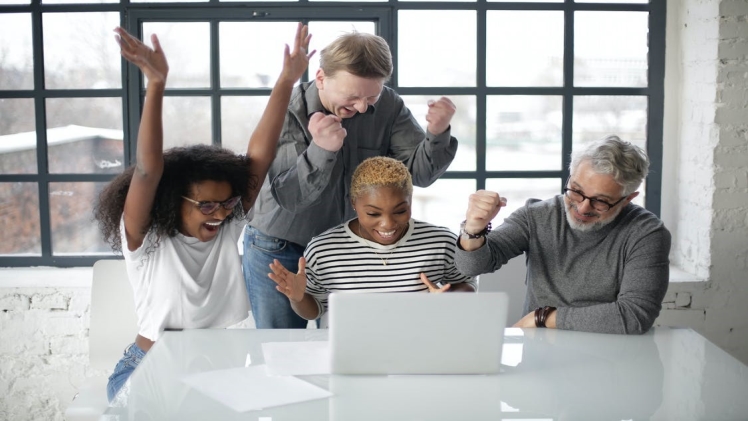 A group of people excited while looking at the laptop screen